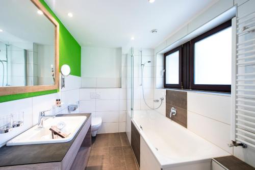 a bathroom with a sink and a toilet and a window at Hotel Erhart Sölden in Sölden