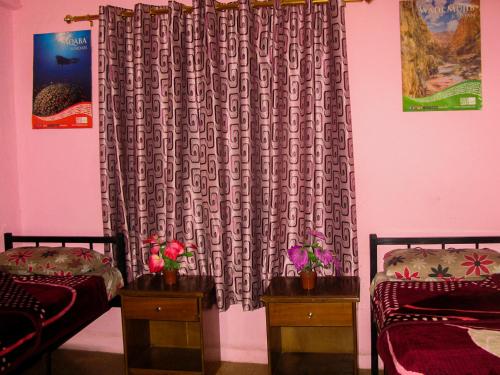 a bedroom with two twin beds and a curtain at Cliff Hostel in Amman