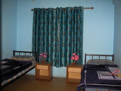 a room with two beds and a green curtain at Cliff Hostel in Amman