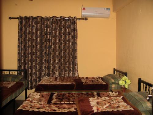a room with two beds and a window with curtains at Cliff Hostel in Amman