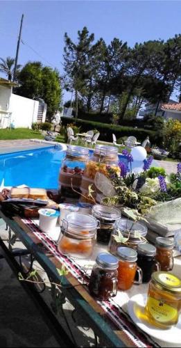 a table with jars of food on it next to a pool at Rooms Romangia in Sorso