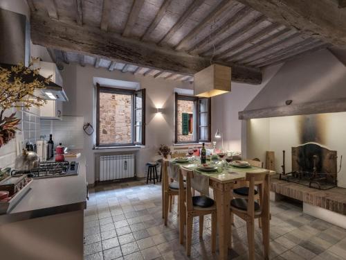 a kitchen with a table and chairs in a room at Apartment La Scala 1572 in San Quirico dʼOrcia
