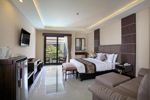 a hotel room with a bed and a living room at d'Penjor Seminyak in Seminyak