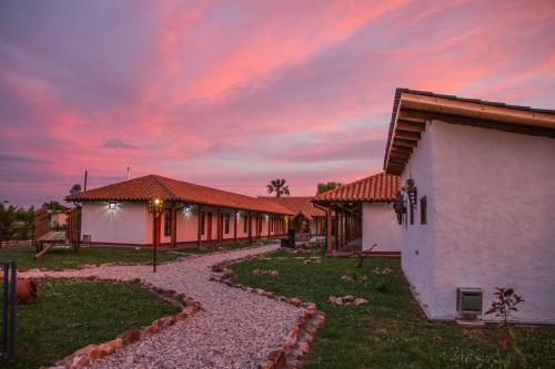 a group of buildings with a sunset in the background at Hotel El Molino in Santa Cruz