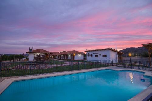 a swimming pool with a sunset in the background at Hotel El Molino in Santa Cruz