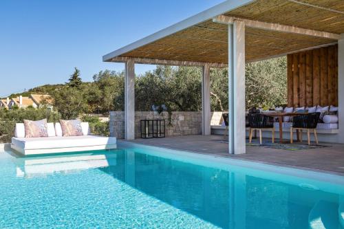 a house with a swimming pool and a pavilion at Artblue Villas in Tsoukaladhes