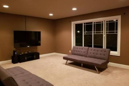 a living room with a couch and a flat screen tv at JOFER Seattle/Renton Home in Renton