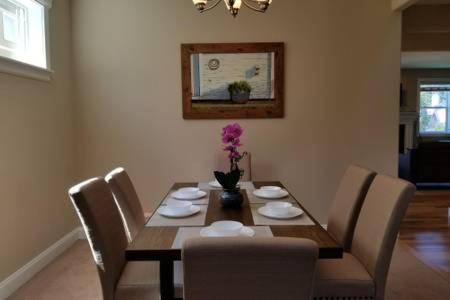 a dining room table with chairs and a vase of flowers at JOFER Seattle/Renton Home in Renton