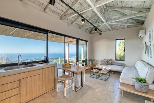 a kitchen and living room with a view of the ocean at Artblue Villas in Tsoukaladhes