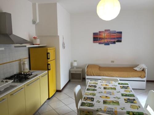 a kitchen with a table and a bed in a room at Hotel Villa Rosa in Porto Azzurro
