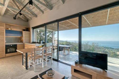 a kitchen and dining room with a view of the ocean at Artblue Villas in Tsoukaladhes