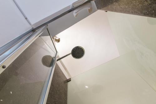 ducha con cabezal de ducha y pared de cristal en Kefa Holiday - Balcone sul Mare, en Cefalú