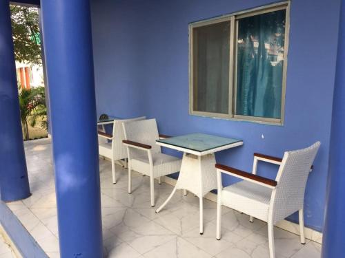 a patio with a table and chairs and a blue wall at Tara Guest House in Bodh Gaya