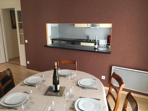 - une table blanche avec une bouteille de vin dans l'établissement Joli 3P avec terrasse et Garage proche Centre, à Strasbourg