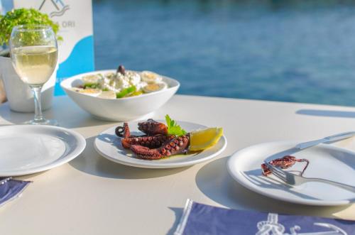 a table with plates of food and a glass of wine at Lefka Ori in Khóra Sfakíon