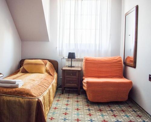 a bedroom with a bed and a chair next to a window at Resort Jura in Kroczyce
