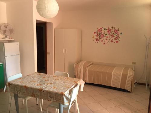 a dining room with a table and a bed at Hotel Villa Rosa in Porto Azzurro