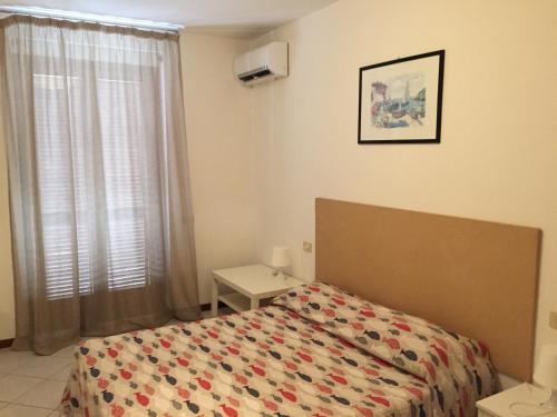 a bedroom with a bed and a window at Hotel Villa Rosa in Porto Azzurro