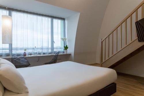 a bedroom with a large white bed and a window at The Originals City, Hôtel Armony, Dijon Sud (Inter-Hotel) in Chenôve