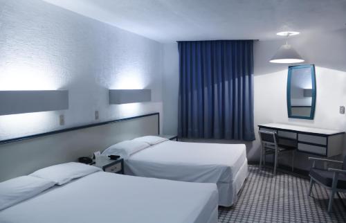 Habitación de hotel con 2 camas y escritorio en HOTEL OLIDEN, en Coatzacoalcos