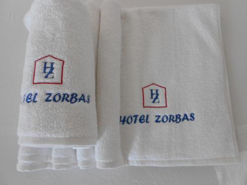 two towels with the words world zoroas on them at Zorbas Hotel & Studios in Pythagoreio