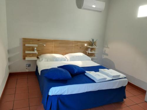 a bedroom with a blue and white bed with blue pillows at Casammare in Marina di Modica