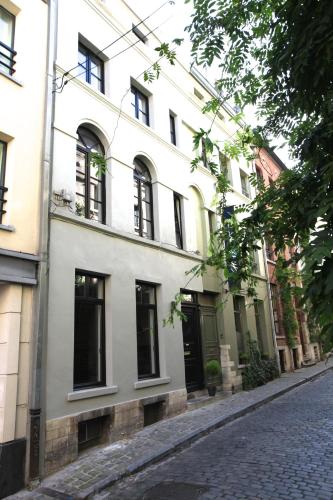 a white building with black windows on a street at Coeur Sablon in Brussels