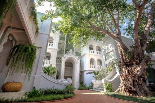 a large white building with a tree in front of it at The Inside House in Chiang Mai