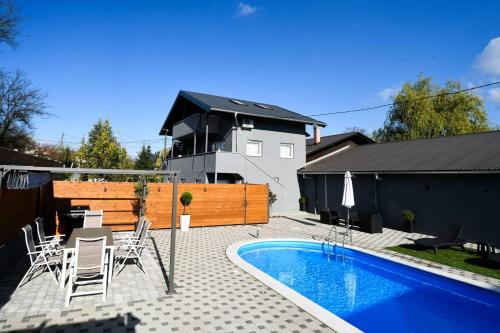 a patio with a pool and chairs and a house at "Oasis of Peace Zagreb-Apartments" in Zagreb