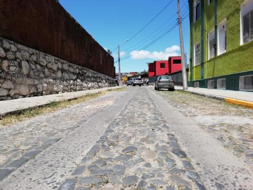 una strada vuota accanto a un muro di pietra di Hostal Dinamarca a Valparaíso