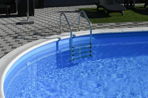a blue swimming pool with stairs in it at "Oasis of Peace Zagreb-Apartments" in Zagreb