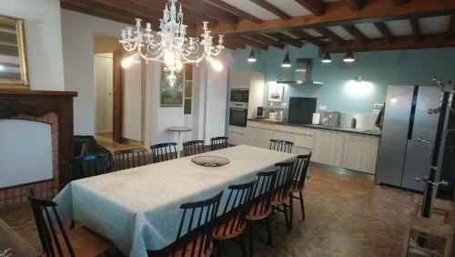 uma sala de jantar com mesa e cadeiras e uma cozinha em Grand gîte - Stella Matutina em Barèges