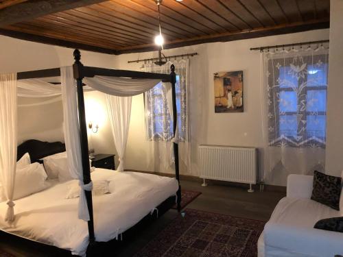 een slaapkamer met een hemelbed en een bank bij Varosi 4 Seasons in Edessa