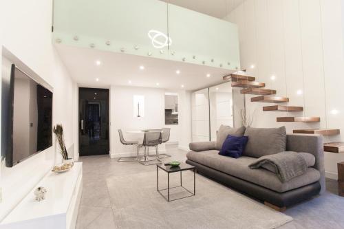 a living room with a couch and a staircase at Stylish Loft with Finnish SAUNA in Budapest