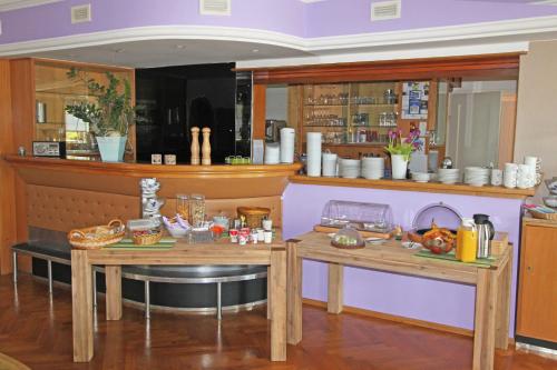 a kitchen with two wooden tables and a counter at Hotel Sonnenhof in Sindelfingen