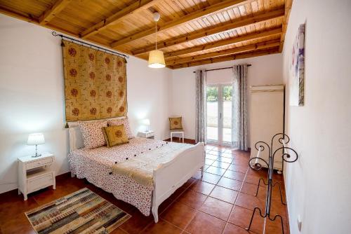 a bedroom with a white bed and a wooden ceiling at Vale do Grou Natura in Óbidos