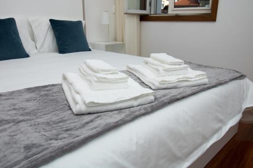 a pile of towels sitting on top of a bed at Casas do Paço - Philosophy Apartments in Braga