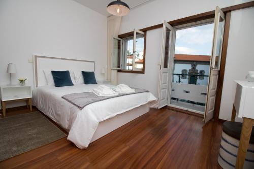 a bedroom with a large bed and a large window at Casas do Paço - Philosophy Apartments in Braga