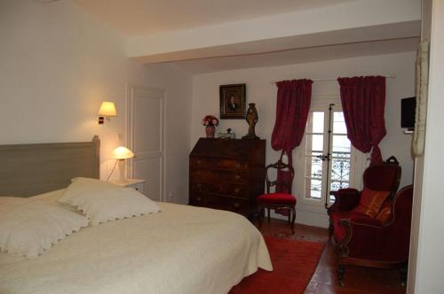 Cauxにあるlamaisonderoseのベッドルーム(白いベッド1台、赤い椅子付)