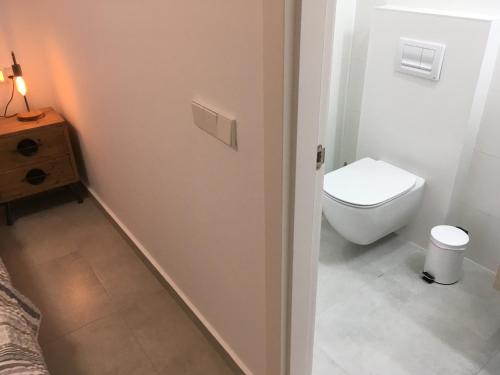 a white bathroom with a toilet and a sink at Apartment "Las Palmeras" in Los Alcázares
