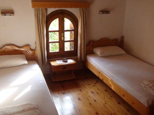 2 Betten in einem Zimmer mit Fenster in der Unterkunft Baha-Ammes in Svoronata