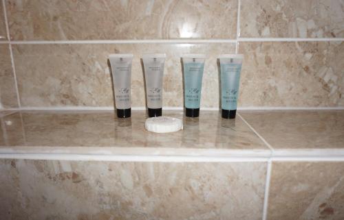 three bottles ofodorizers sitting on a shelf in a bathroom at The Coach House in Bristol