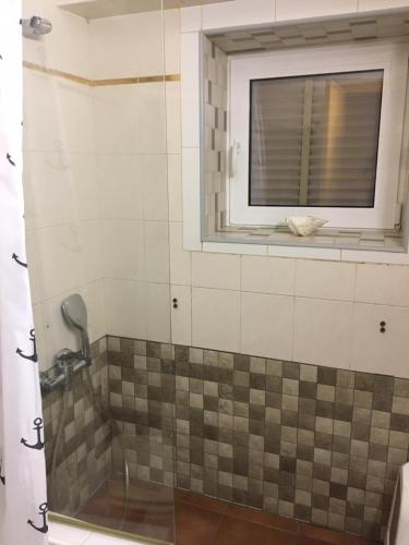 y baño con ducha y ventana. en APARTAMENTO L'ESCALA, en L'Escala