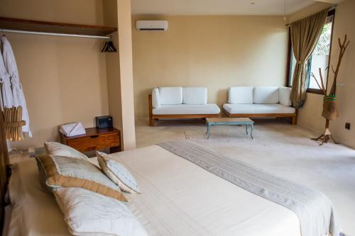 a bedroom with a bed and a couch and a table at Maria Del Mar Tulum - Adults Only in Tulum