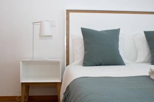 a bedroom with a bed and a night stand with a lamp at Casas do Paço - Philosophy Apartments in Braga