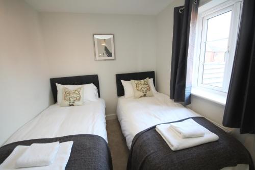 2 camas individuales en una habitación con ventana en The Hanwell en Banbury