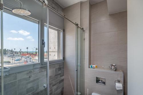 a bathroom with a shower and a window with a view at Beautiful Sunny 3 bedrooms in font of the beach in Tel Aviv