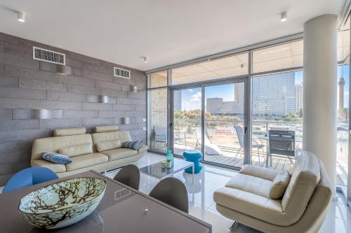 a living room with couches and a glass table at Beautiful Sunny 3 bedrooms in font of the beach in Tel Aviv