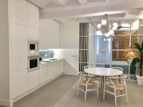 バレンシアにあるApartamento Frederick “Centrico y con Clase”の白いキッチン(テーブル、椅子付)