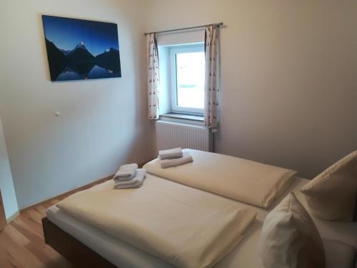 two beds in a room with a window at Appartement Großwallner in Radstadt